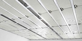 Die Decke zeigt ein modernes Design mit perforierten Platten und metallischen Rahmen, die eine klare Struktur bilden.