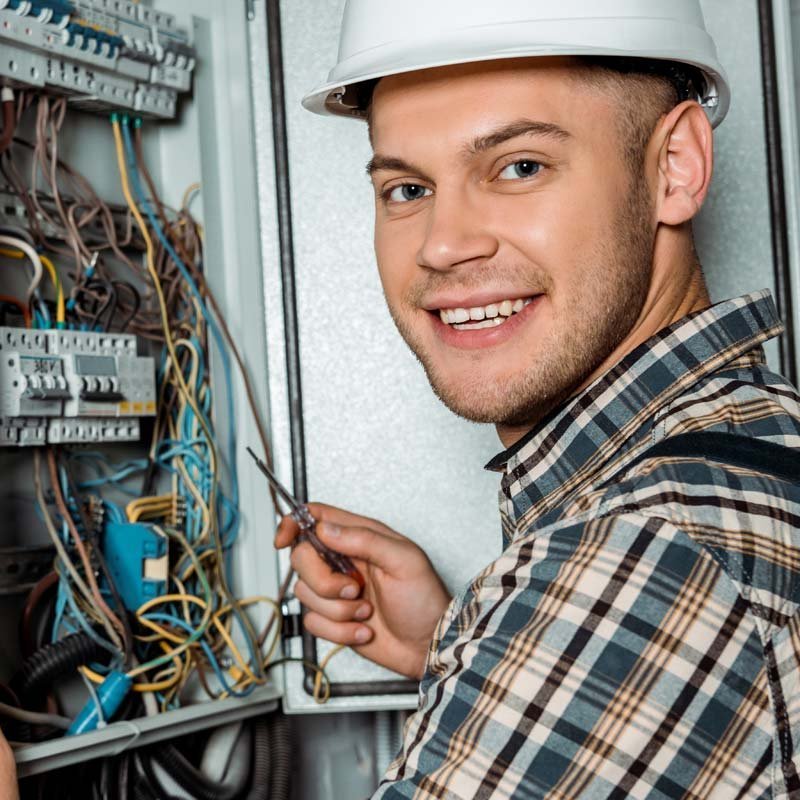 EIn Elektroniker der an einem Verteilerkasten arbeitet