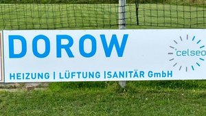 Ein großes Werbeschild mit dem Namen 'DOROW' und den Dienstleistungen Heizung, Lüftung und Sanitär in blauer Schrift.