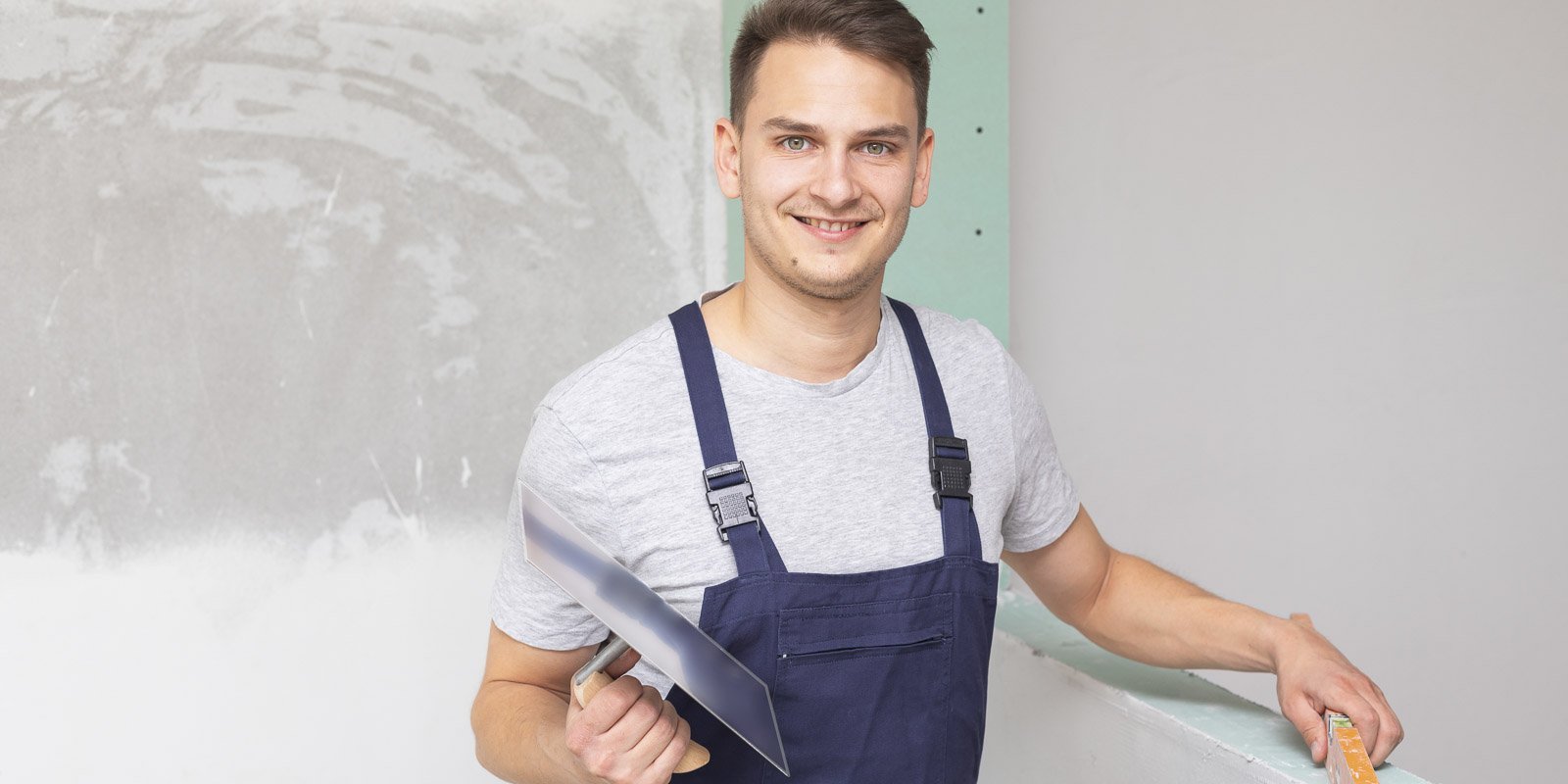 EIn junger Mann in Arbeitskleidung