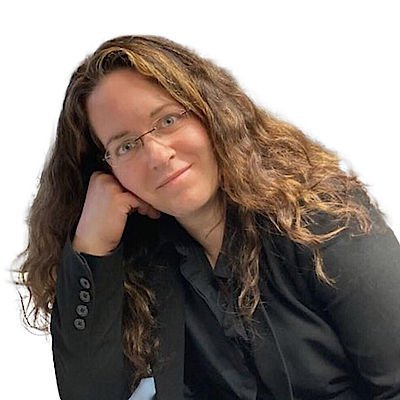 Die Frau mit Brille und lockigem Haar blickt freundlich, während sie entspannt mit der Hand auf ihrem Kinn ruht.