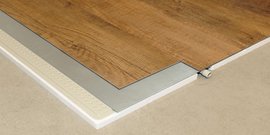 Der Übergang zwischen einem Holzfußboden und einem grauen Sockel ist klar sichtbar, mit einem modernen und eleganten Design.